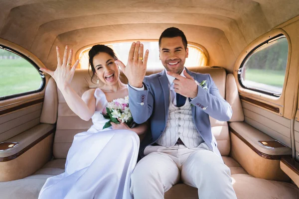 Blurred Newlyweds Showing Rings Retro Car — Stock Photo, Image