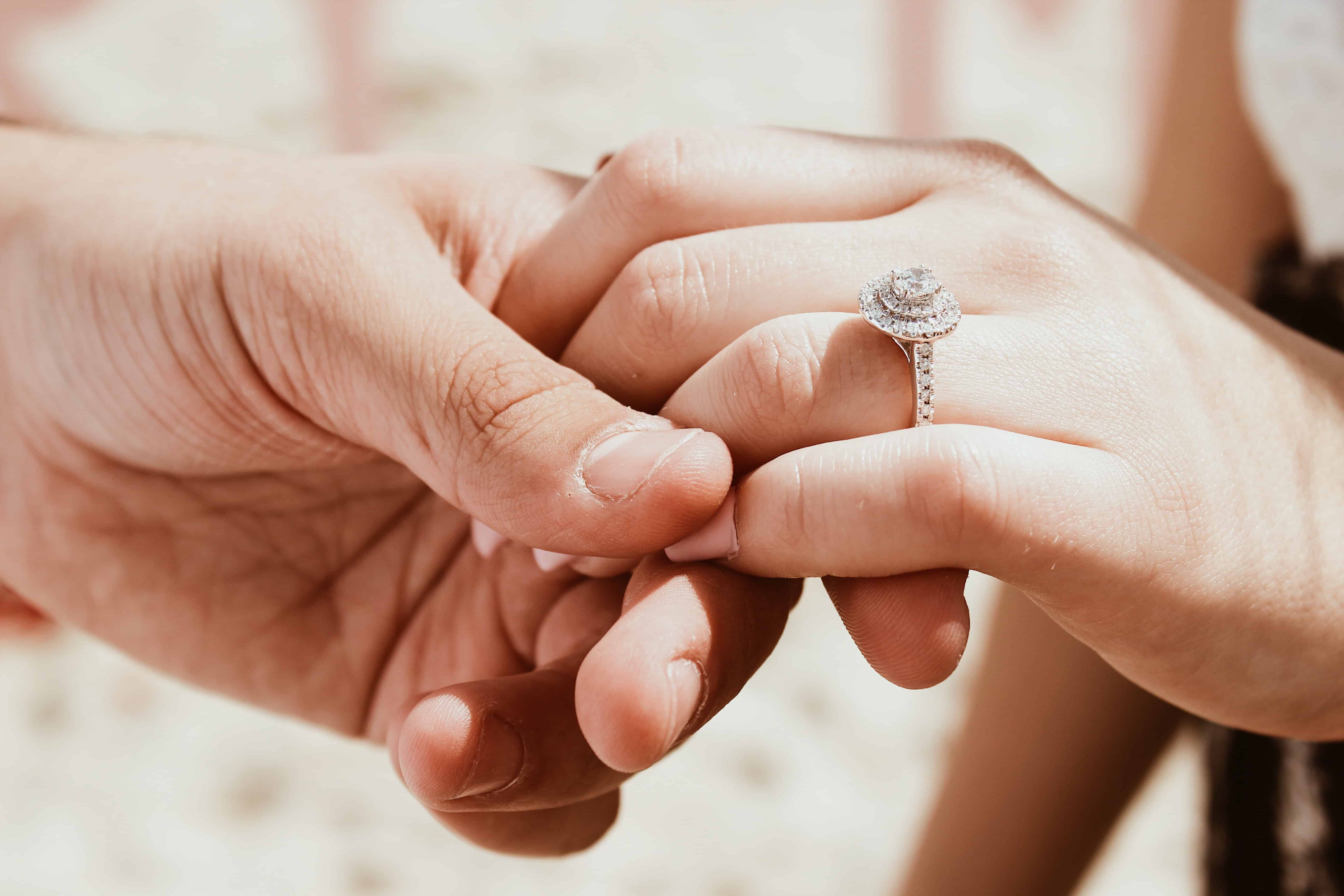 person holding another person's hand with ring