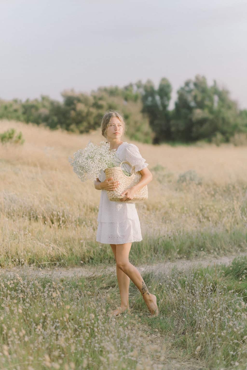 Woman in White Dress Holding Brown Wicker Basket