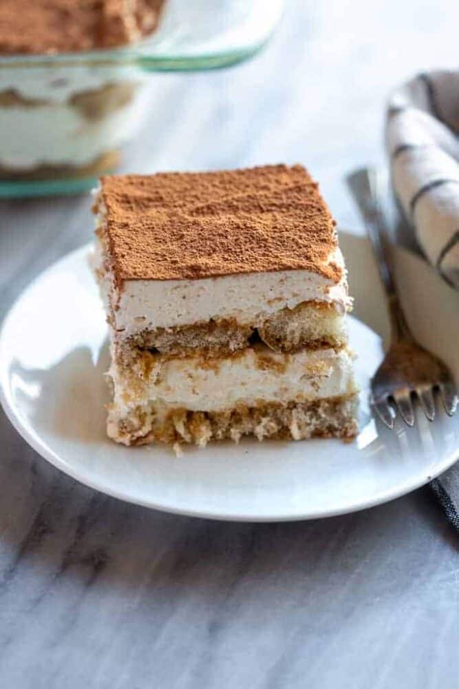 A slice of homemade tiramisu on a white plate.